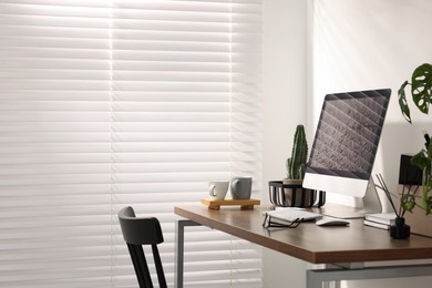 Photo of Cozy workspace with computer on wooden desk at home