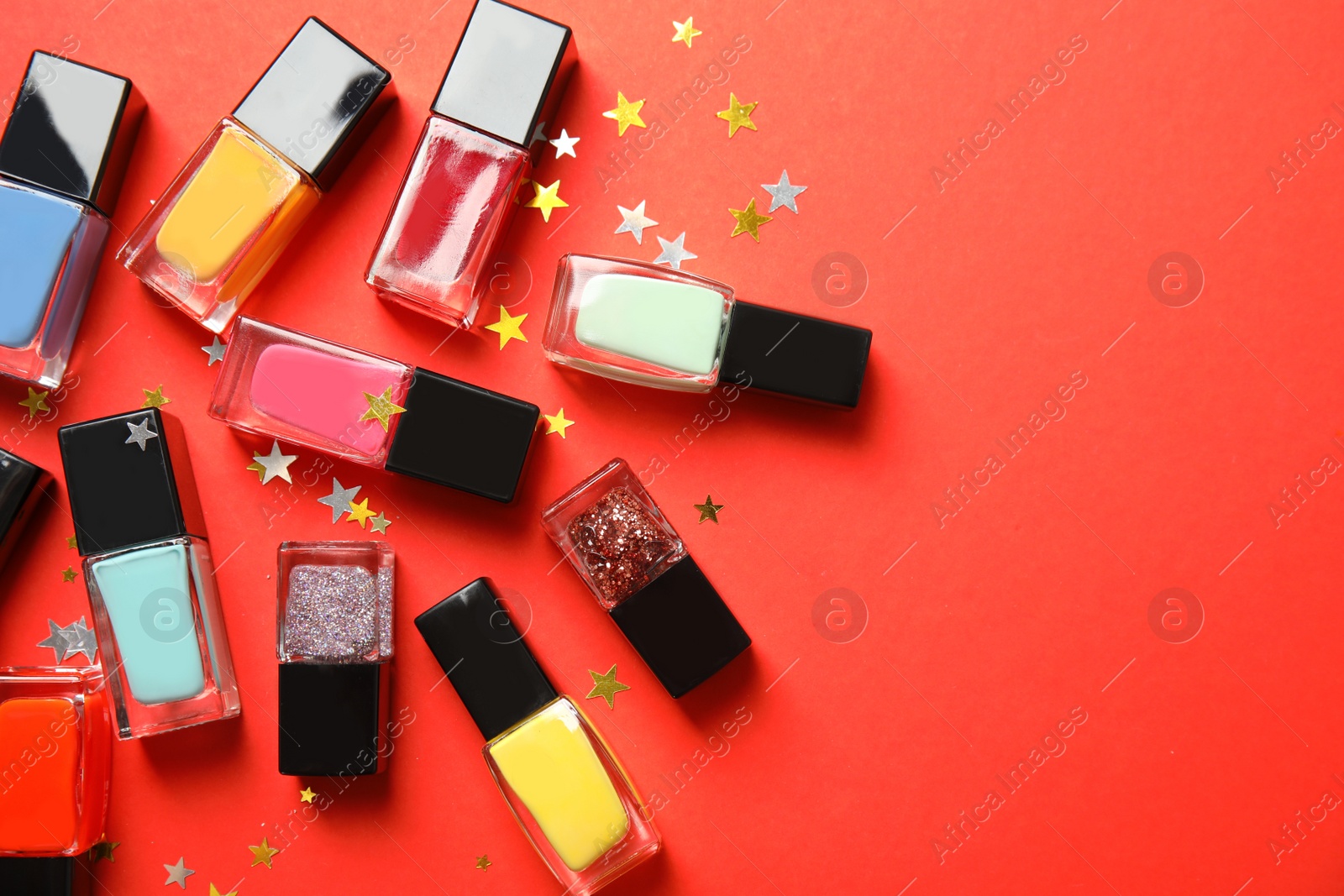 Photo of Bottles of nail polish on color background, top view with space for text