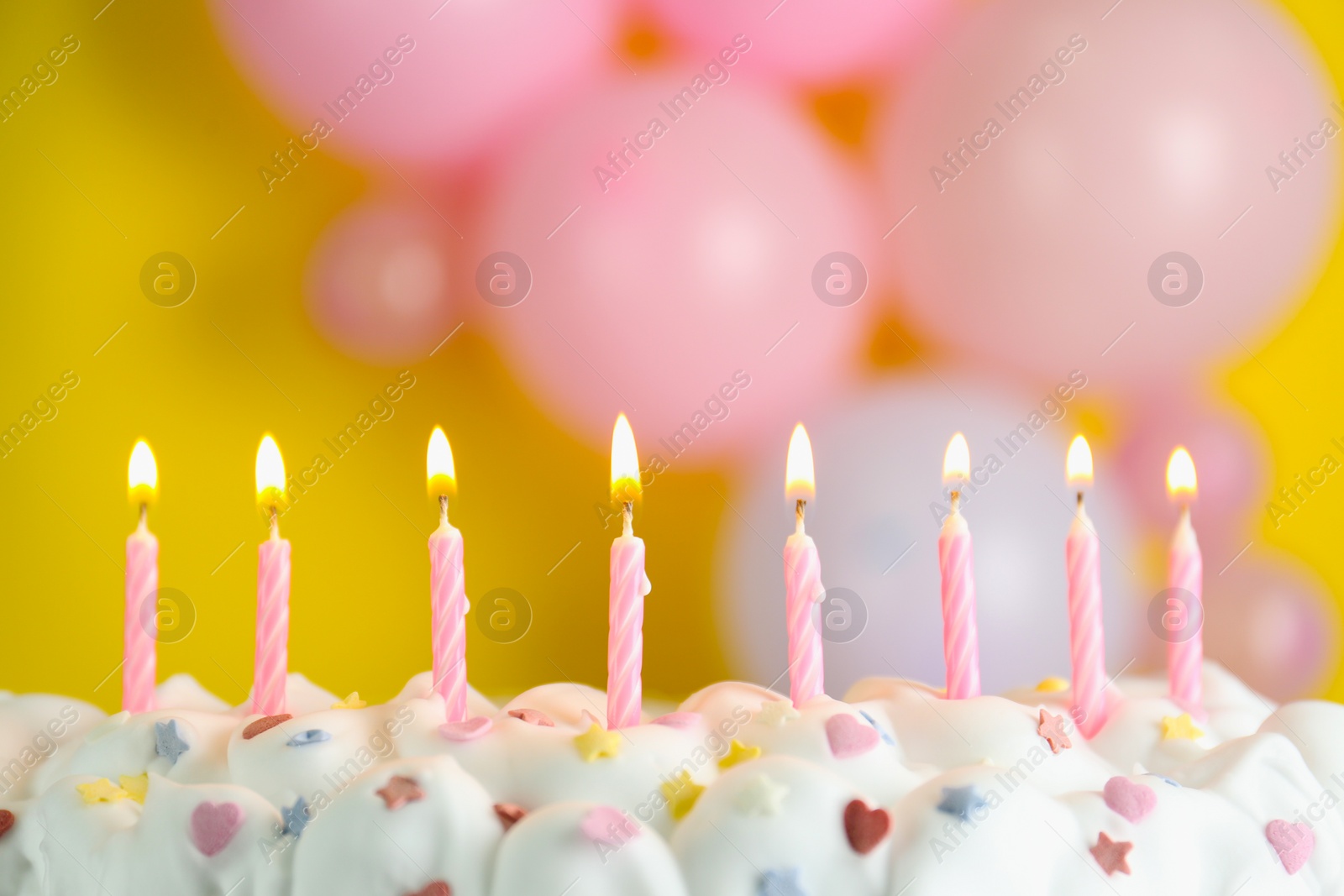 Photo of Birthday cake with burning candles on blurred background, closeup