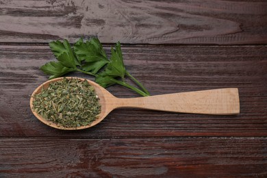 Spoon of dried aromatic parsley and fresh leaves on wooden table, flat lay