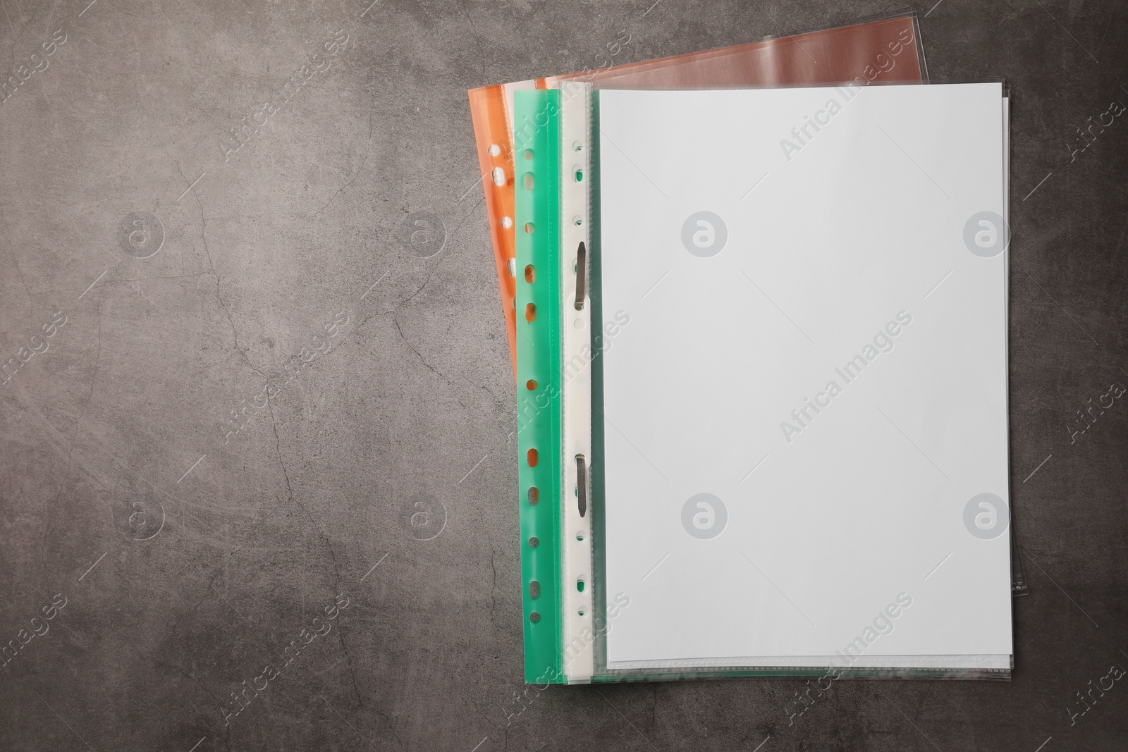 Photo of File folders with punched pockets on grey table, flat lay. Space for text