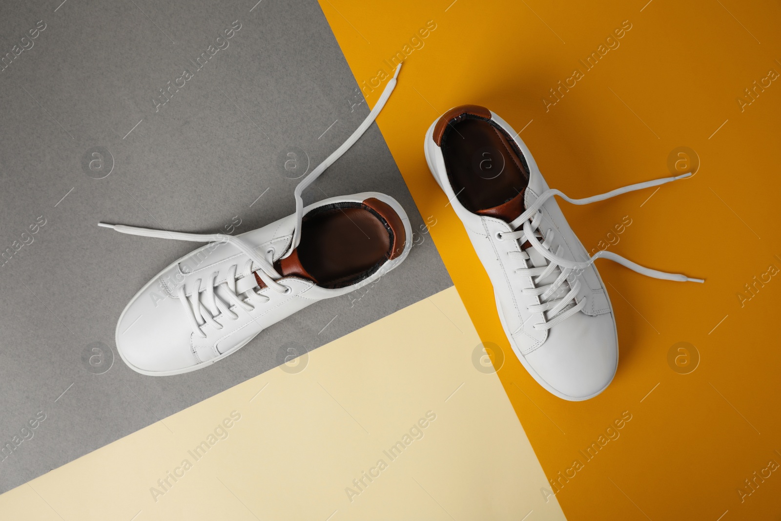 Photo of Pair of stylish white sneakers on color background, flat lay