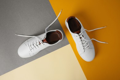 Photo of Pair of stylish white sneakers on color background, flat lay