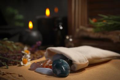 Photo of Bag with gemstones and healing herbs on table