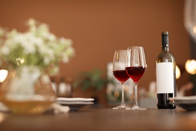 Glasses and bottle with tasty wine on table in restaurant