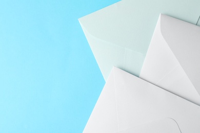 White paper envelopes on light blue background, flat lay. Space for text