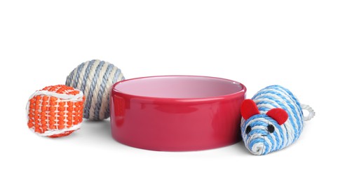 Feeding bowl and toys for pet on white background