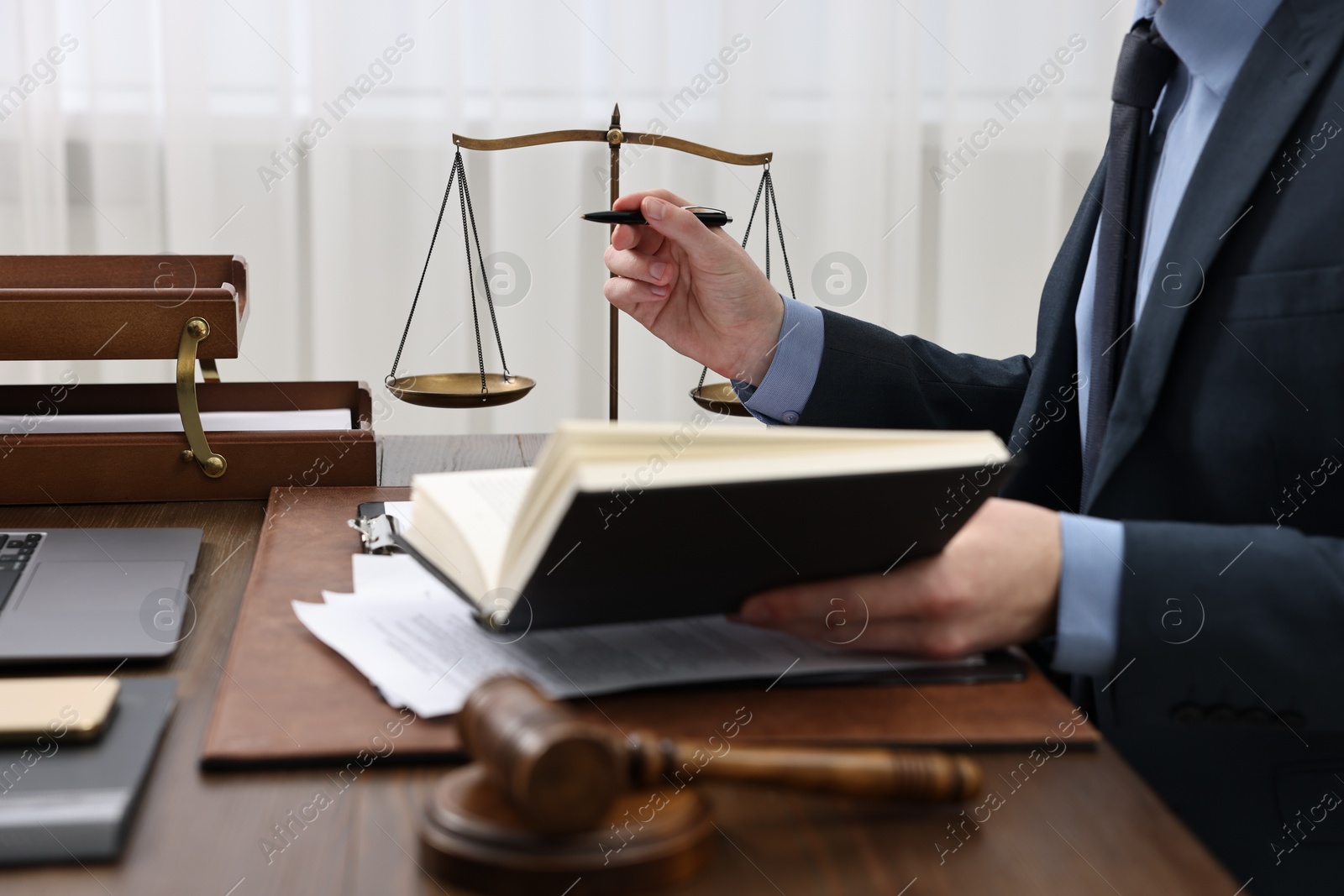 Photo of Lawyer working with documents at wooden table indoors, closeup