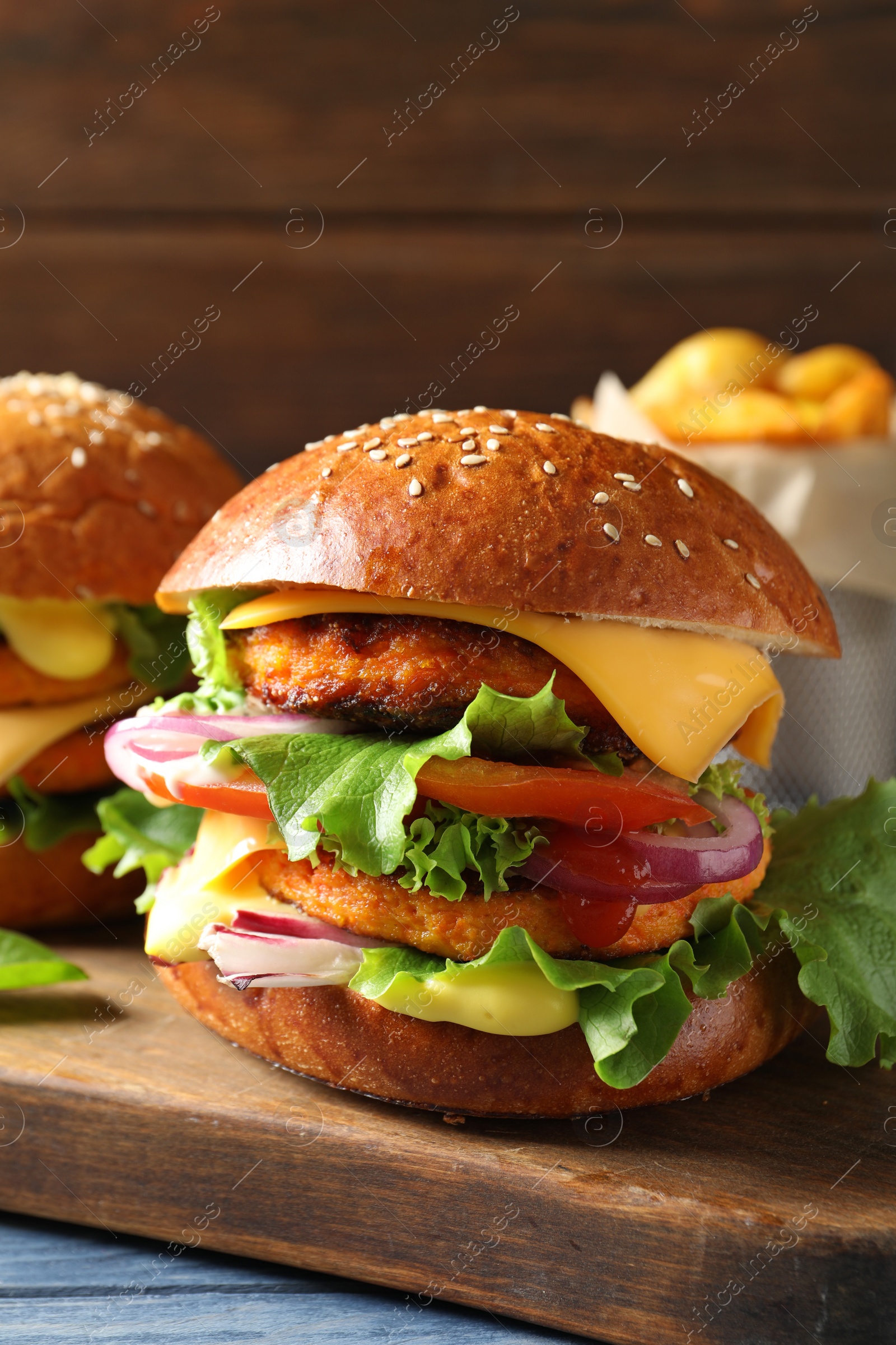 Photo of Wooden board with double vegetarian burgers on table
