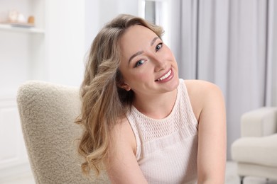 Photo of Portrait of smiling woman with curly hair at home