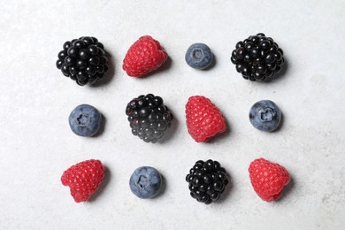 Many different fresh ripe berries on white textured table, flat lay
