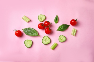 Flat lay composition with fresh ingredients for salad on pink background