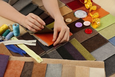 Photo of Woman choosing among colorful fabric samples, closeup