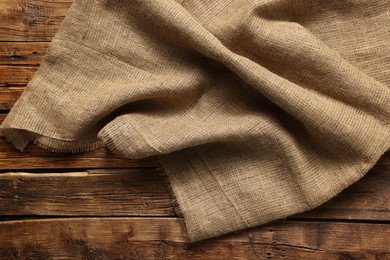 Burlap fabric on wooden table, top view