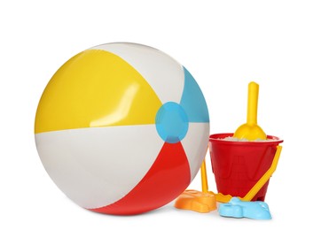 Photo of Inflatable colorful beach ball and child plastic toys on white background