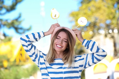 Photo of Young happy woman with sweet candies outdoors