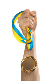 Man holding golden medal on white background, closeup. Space for design