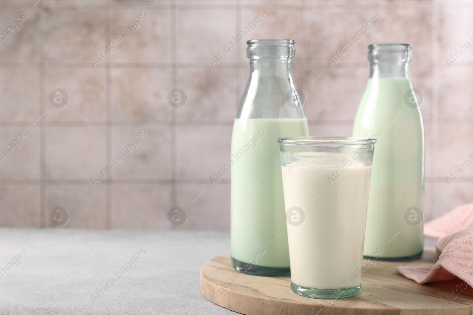 Photo of Glassware with tasty milk on light table, space for text