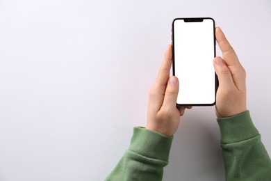 Photo of Man with smartphone on white background, top view. Space for text