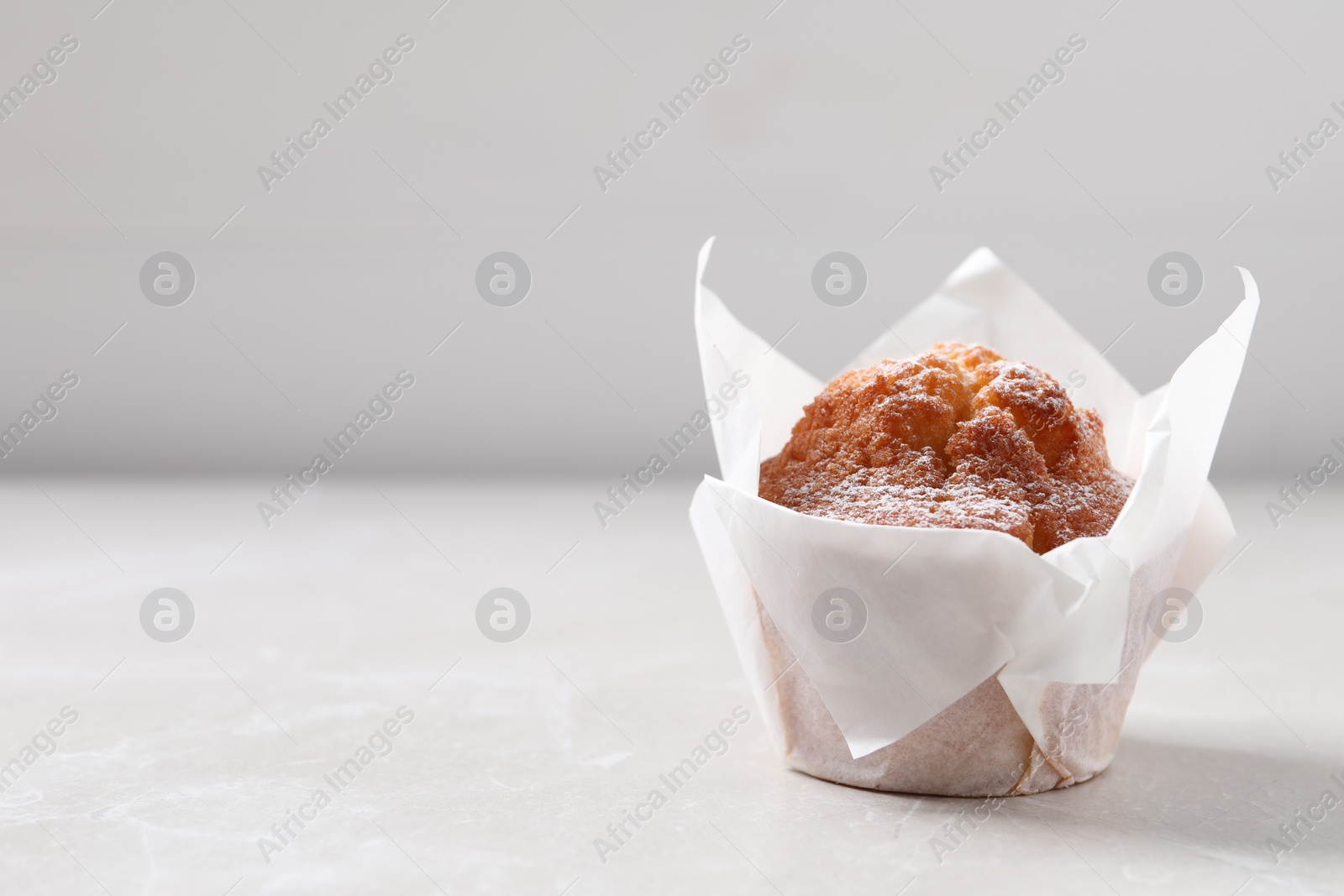 Photo of Delicious muffin on light table. Space for text