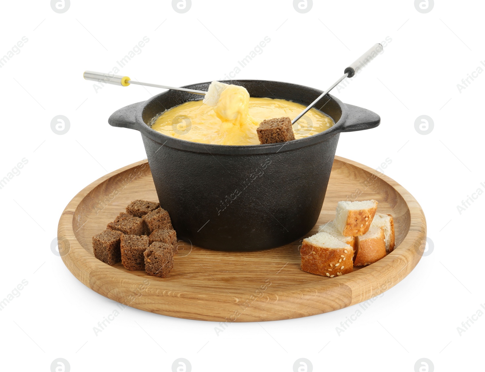 Photo of Fondue with tasty melted cheese, forks and pieces of bread isolated on white