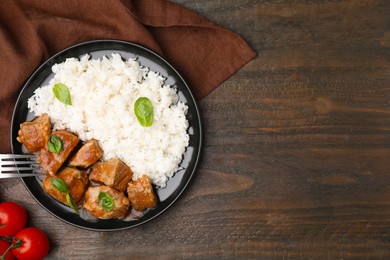 Delicious goulash served with rice on wooden table, flat lay. Space for text