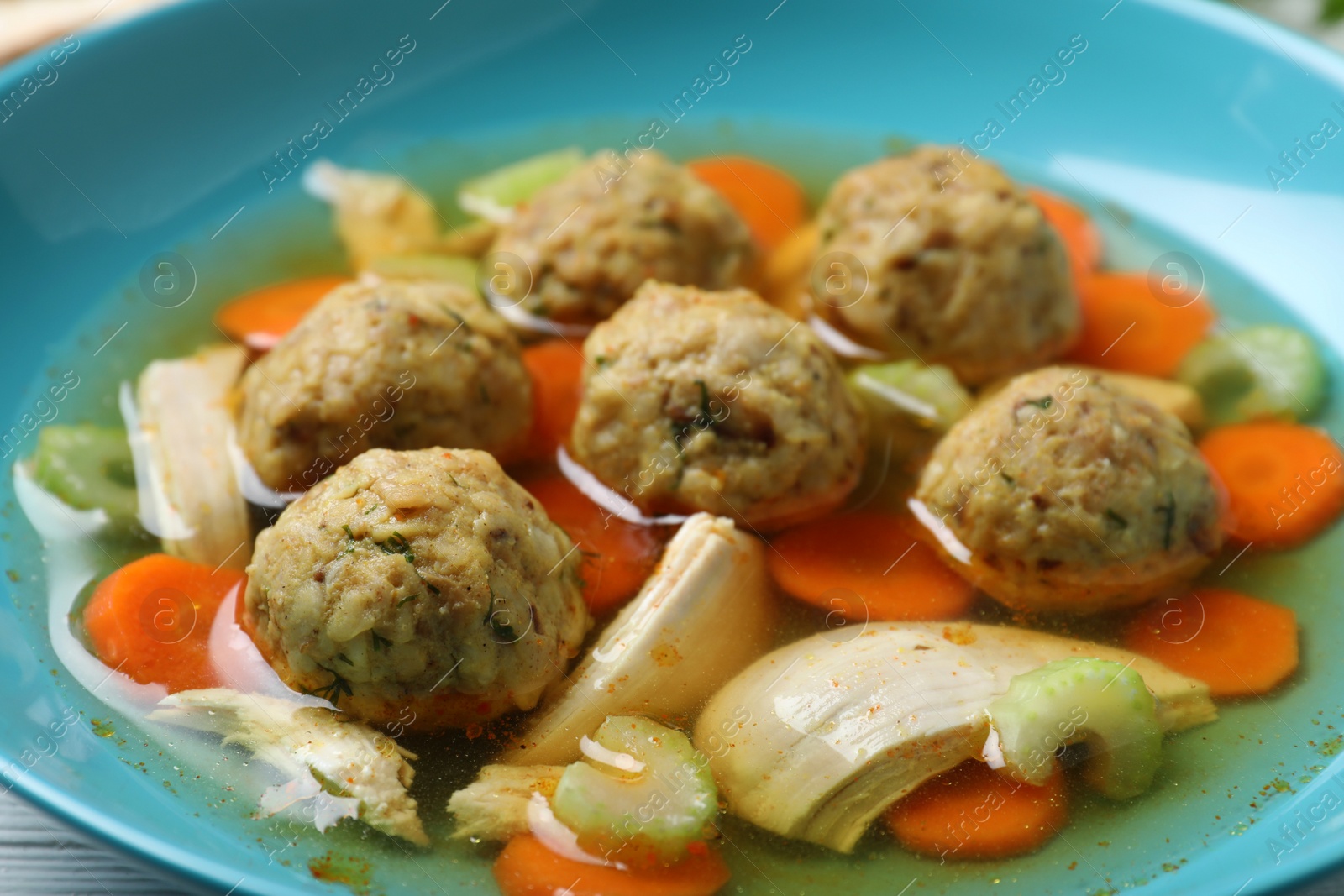 Photo of Tasty Jewish matzoh balls soup in bowl, closeup