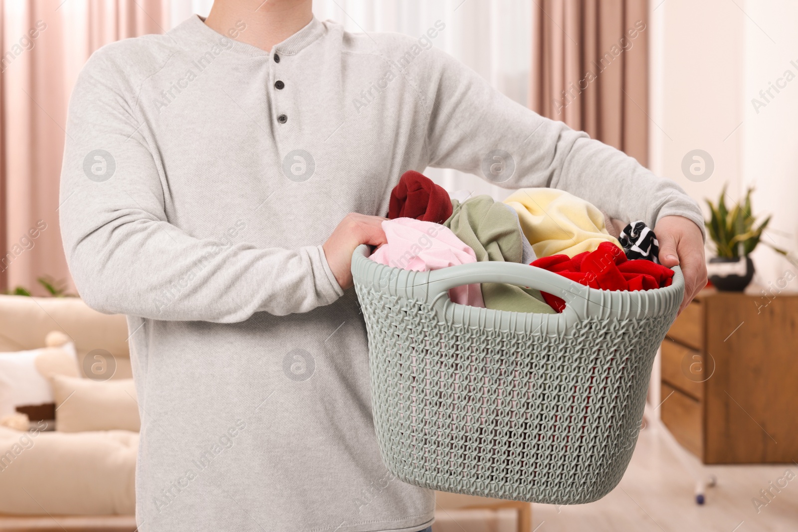 Photo of Man with basket full of laundry at home, closeup