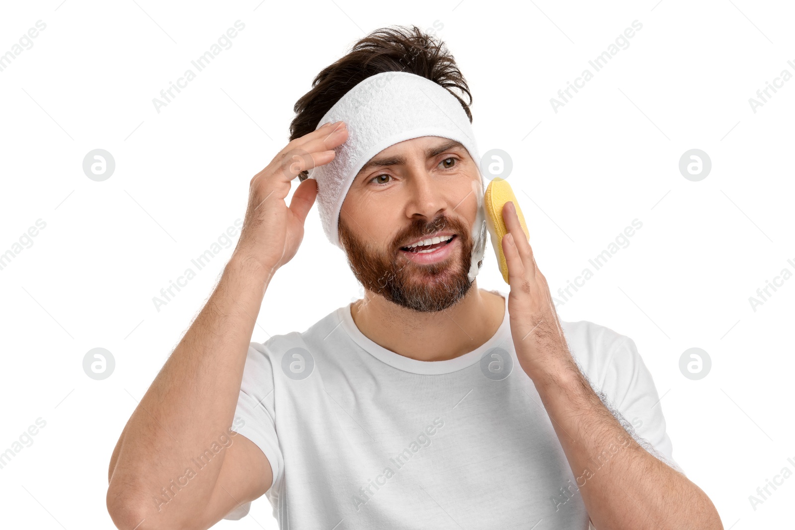 Photo of Man with headband washing his face using sponge on white background