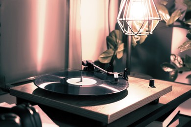 Image of Stylish turntable with vinyl record on table indoors. Black white filter
