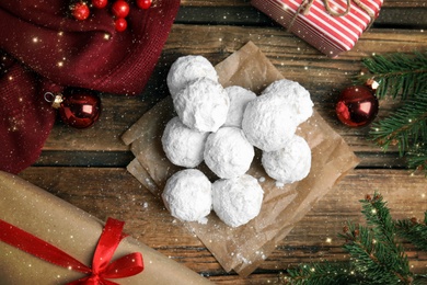 Image of Tasty snowball cookies and Christmas decorations on wooden table, flat lay