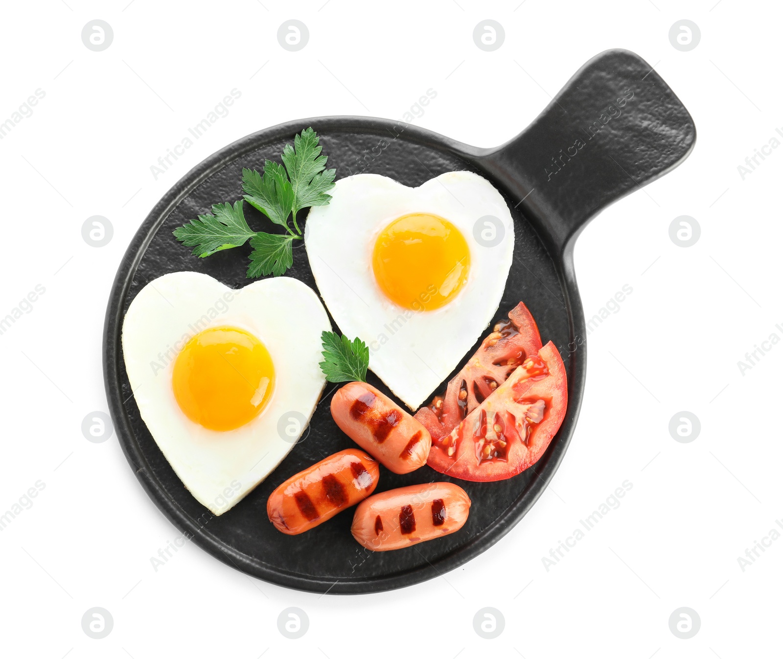 Photo of Slate plate of tasty breakfast with heart shaped fried eggs and sausages isolated on white, top view