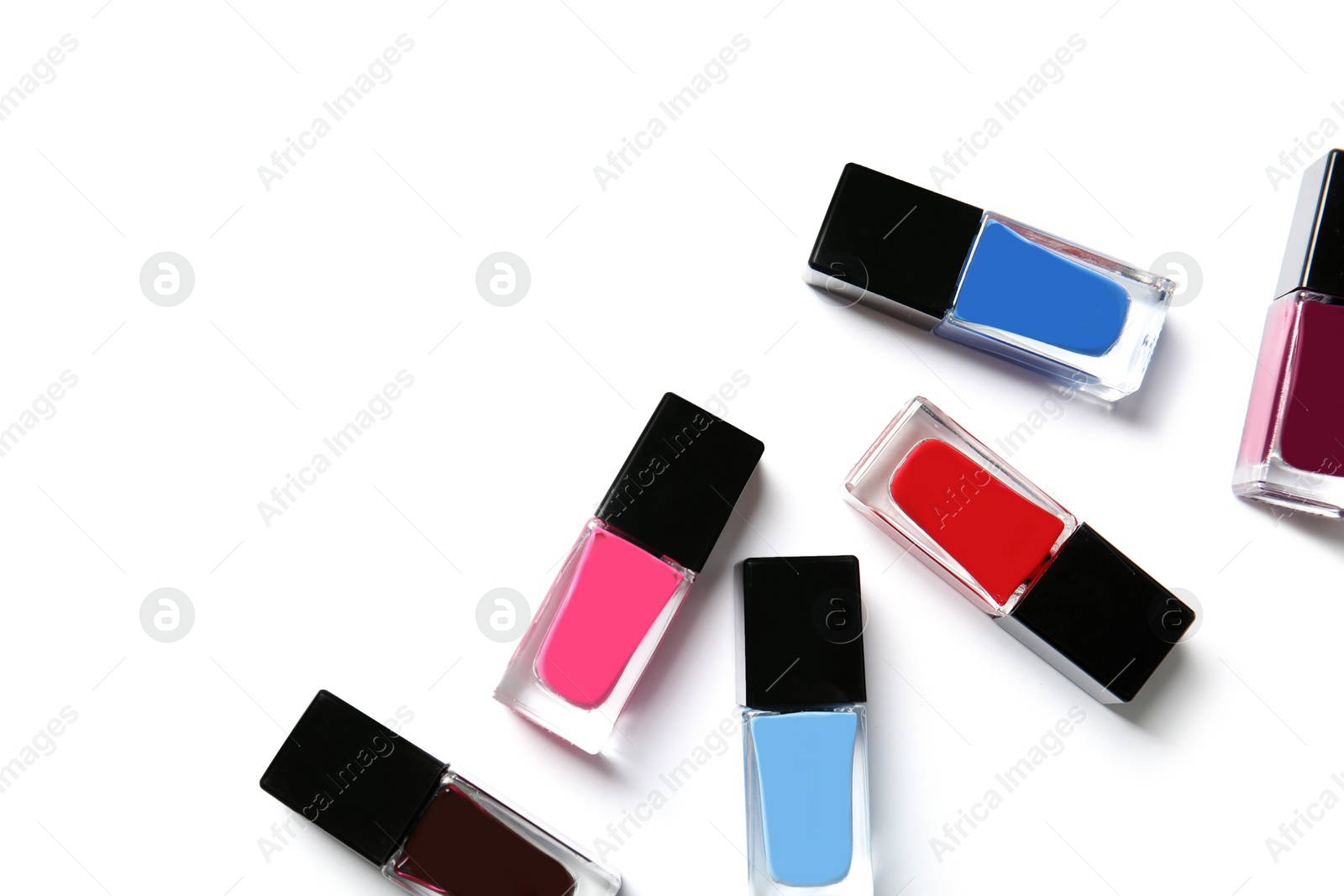 Photo of Bottles of nail polish on white background, top view