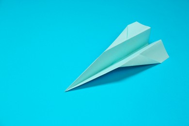 Photo of Paper plane on light blue background, space for text