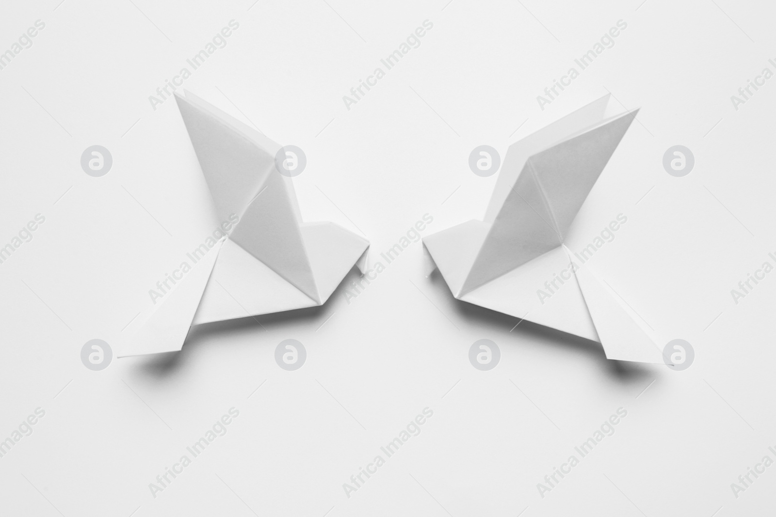 Photo of Beautiful origami birds on white background, flat lay