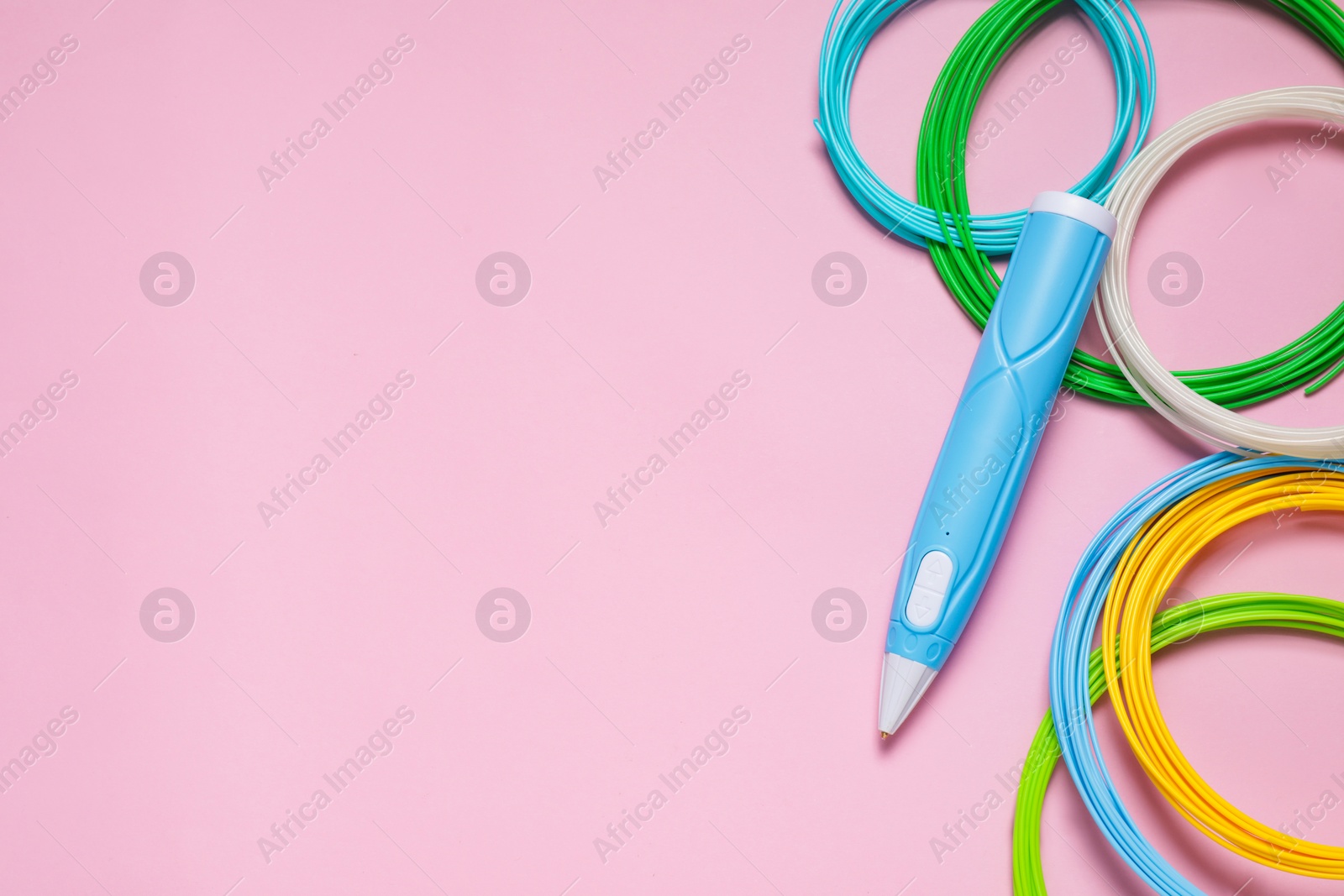 Photo of Stylish 3D pen and colorful plastic filaments on pink background, flat lay. Space for text