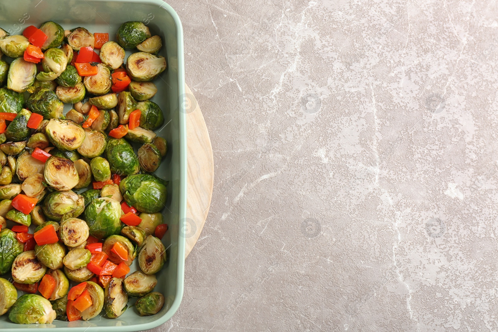 Photo of Delicious roasted brussels sprouts with bell pepper and peanuts on marble table, top view. Space for text