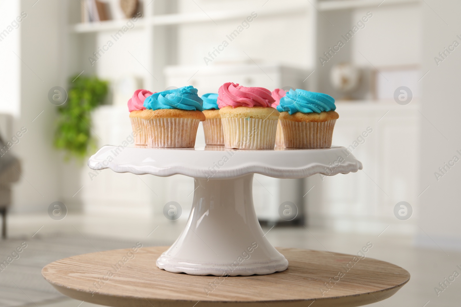 Photo of Delicious cupcakes with bright cream on wooden table indoors