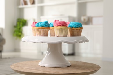 Delicious cupcakes with bright cream on wooden table indoors