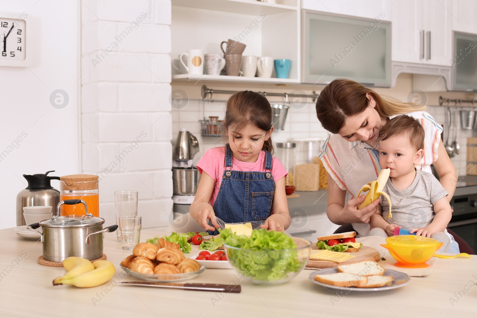 Photo of Housewife preparing dinner with her children on kitchen