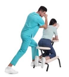 Woman receiving massage in modern chair on white background