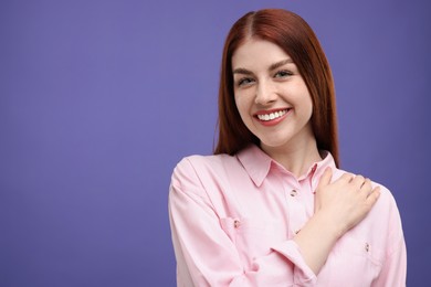 Portrait of smiling woman on purple background. Space for text