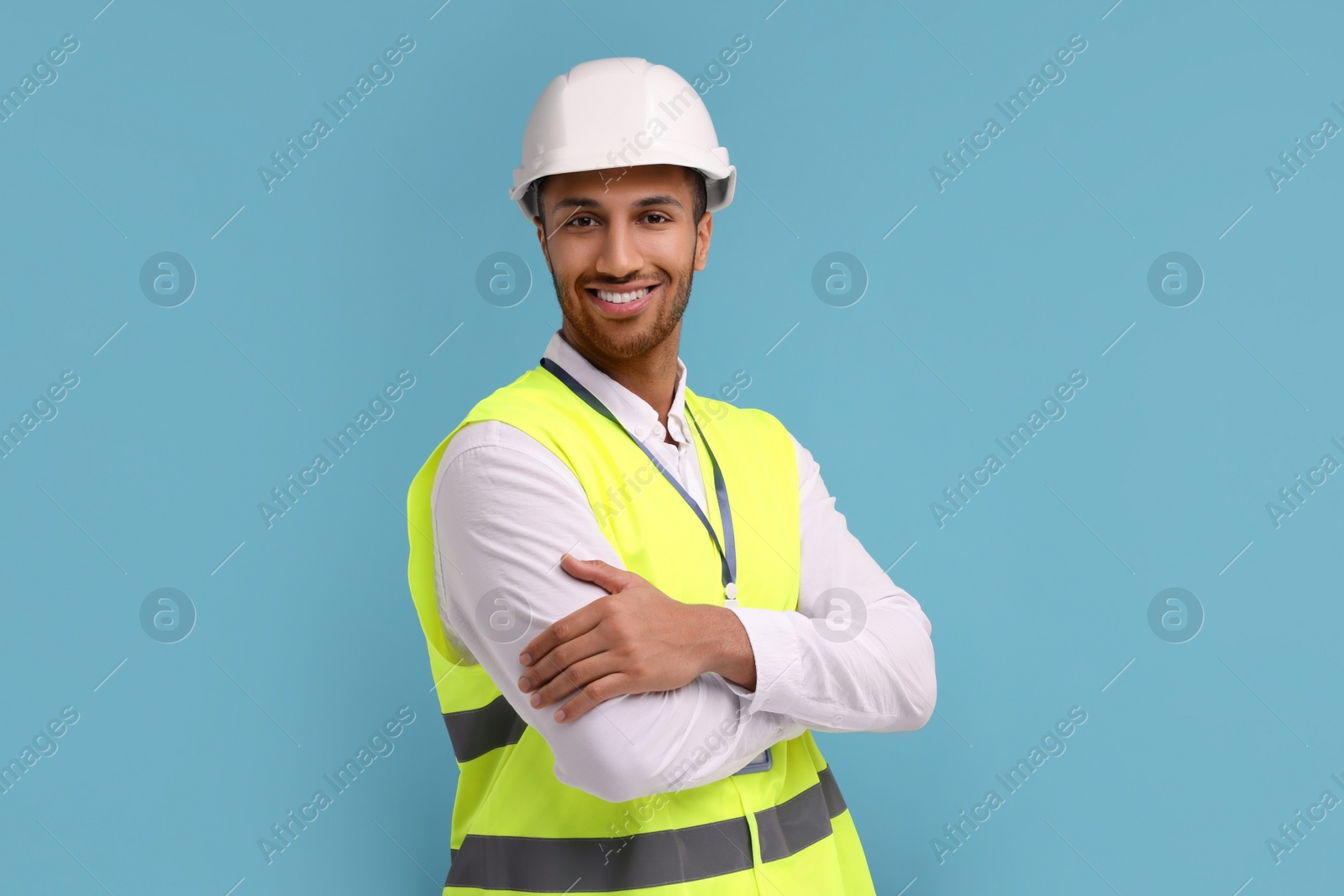 Photo of Engineer in hard hat on light blue background