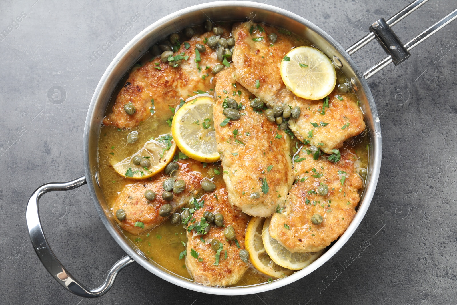 Photo of Delicious chicken piccata on grey table, top view