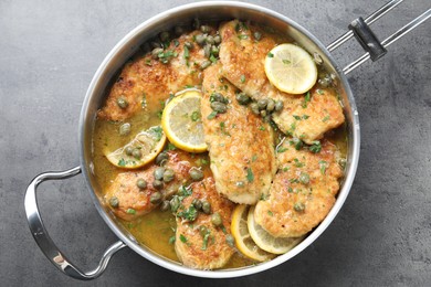 Delicious chicken piccata on grey table, top view