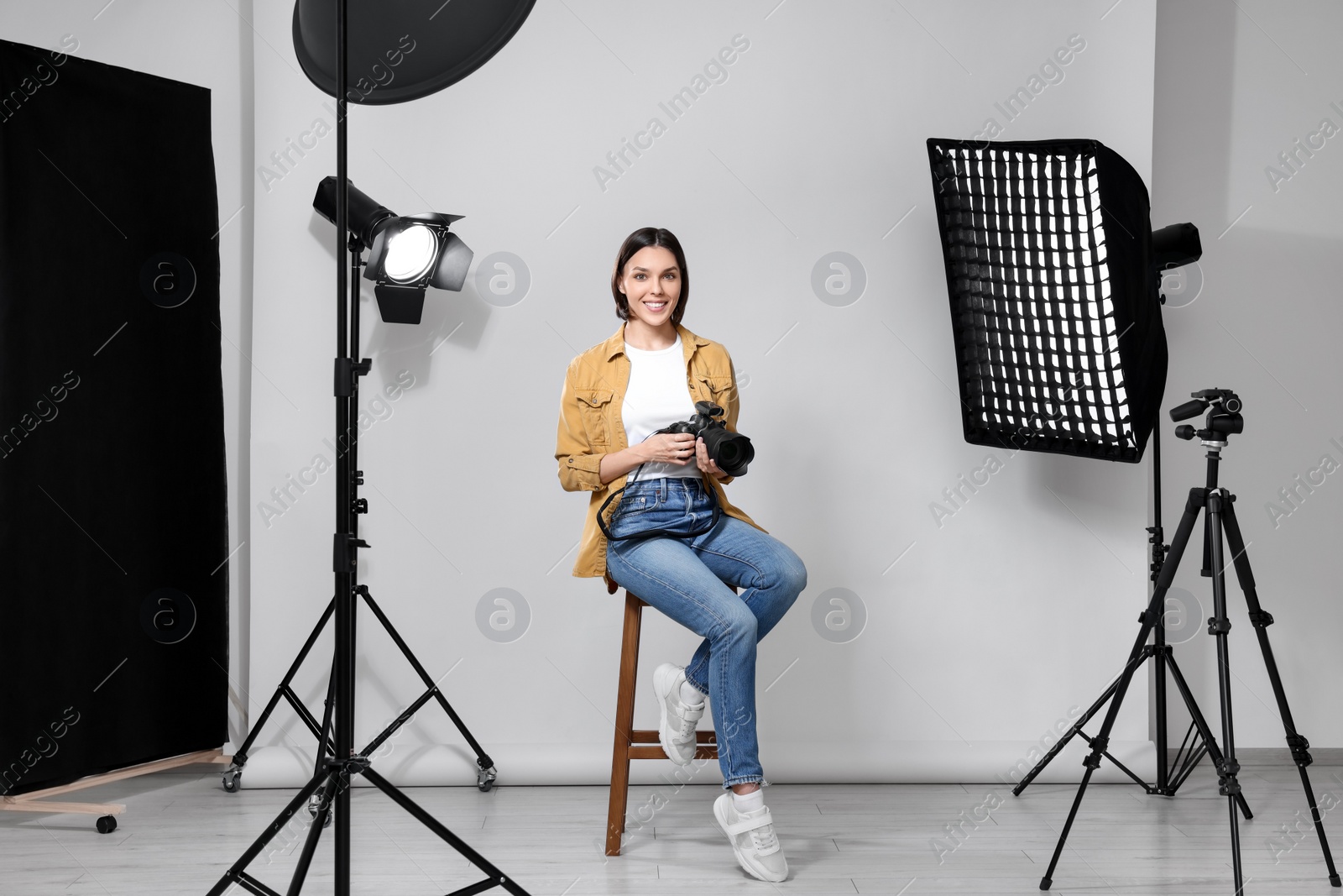 Photo of Professional photographer with camera in modern photo studio