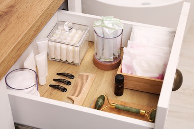 Open cabinet drawer with tampons and feminine hygiene products