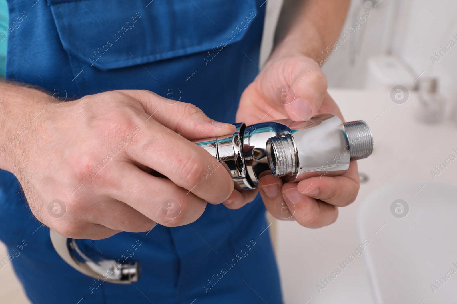 Photo of Professional plumber fixing water tap in bathroom, closeup