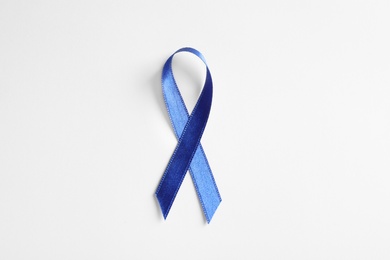 Photo of Blue ribbon on white background, top view. Cancer awareness