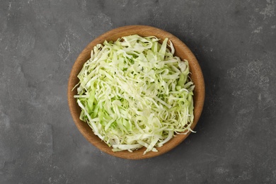 Photo of Chopped cabbage in bowl on grey table, top view